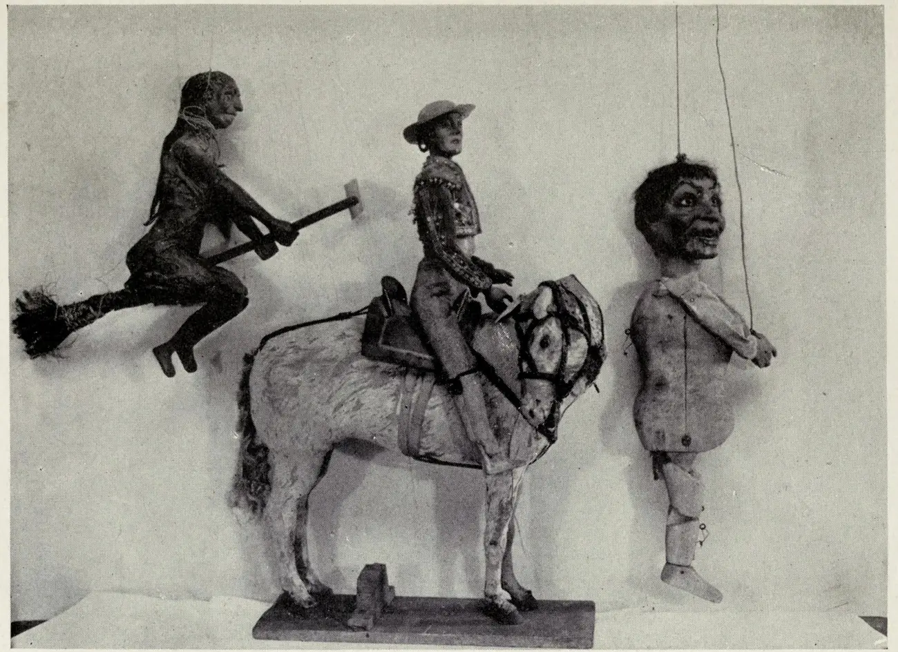 A photographic plate of wooden Spanish marionettes: a flying figure wielding a hammer, a rider in formal dress on horseback, and a hanging puppet with visible strings and an open-mouthed expression.
